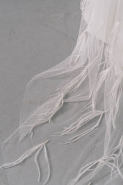Long bridal wedding veil with feather embellishments in 1920s flapper style
